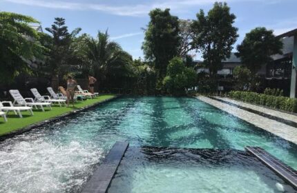 ChaoKoh Phi Phi Hotel & Resort pool view. Gay-friendly hotel with sunbeds, lush greenery, and clear turquoise water. Ideal for gay travel.