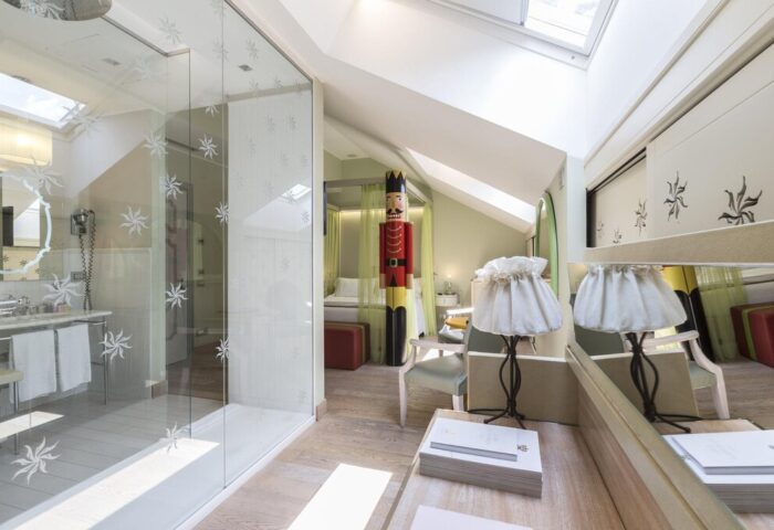 Gay-friendly Chateau Monfort Hotel room. Luxury design with glass shower, nutcracker statue, & skylight. Milan hotel for gay men travel.