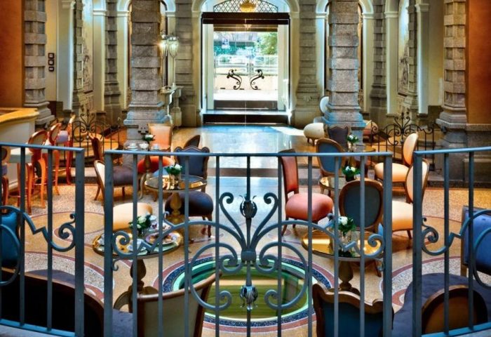 Chateau Monfort Hotel's elegant interior. A gay-friendly hotel with stylish seating around a central fountain. Ideal for gay men's travel.