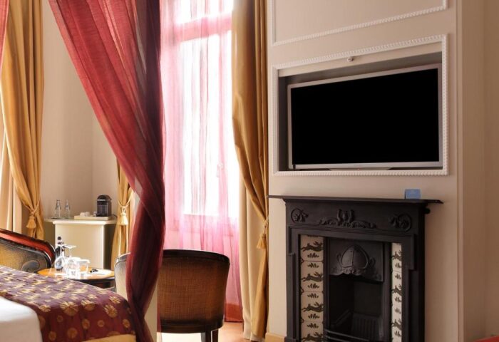 Chateau Monfort Hotel room. Gay-friendly hotel with fireplace, TV, red drapes, and luxury bedding. A great choice for gay men travelers.