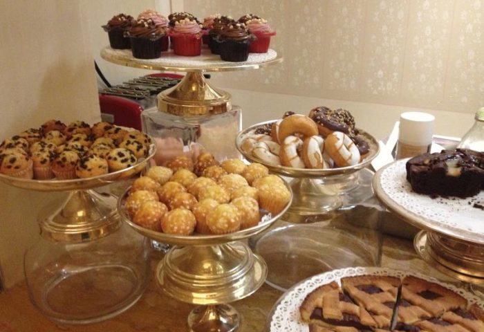 Chateau Monfort Hotel's breakfast buffet with muffins, cupcakes, donuts, cake, and pie on silver tiered stands. Gay-friendly hotel breakfast.