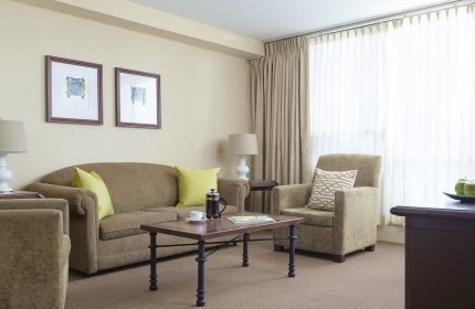Chelsea Hotel Toronto room. Gay-friendly hotel with a seating area, sofa, and coffee table. Comfortable, welcoming accommodations.