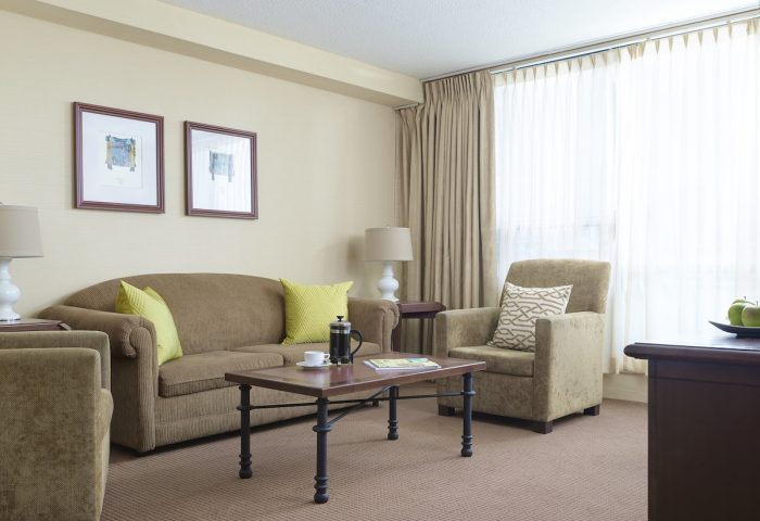 Chelsea Hotel Toronto room. Gay-friendly hotel with a seating area, sofa, and coffee table. Comfortable, welcoming accommodations.