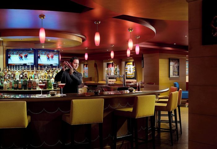 Chelsea Hotel Toronto's bar. Bartender mixes drinks. Gay-friendly hotel with TVs, sports decor, and a lively atmosphere.