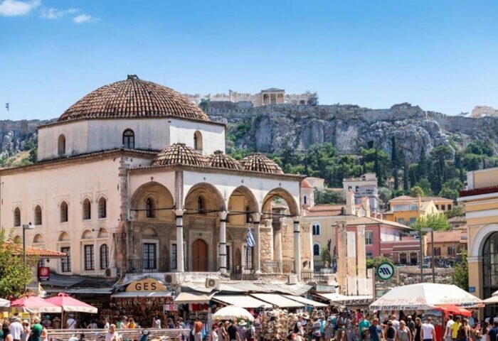 Athens, Greece: Gay-Friendly Chic Hotel view, featuring the Acropolis. A bustling marketplace scene in front of the hotel. Great for gay travel.