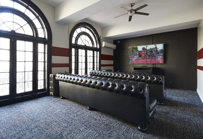 Chicago Getaway Hostel's gay-friendly hotel room. Black leather sofas, large windows, and a TV create a welcoming space. Great for gay travel.