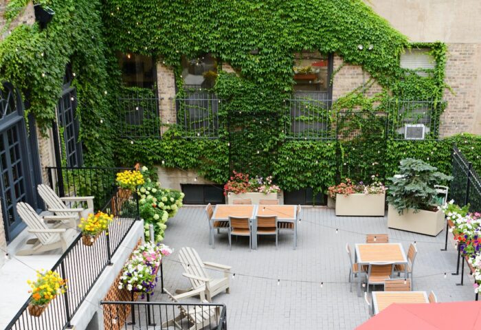 Chicago Getaway Hostel's gay-friendly hotel courtyard. Outdoor seating, tables, and ivy-covered walls create a welcoming space.