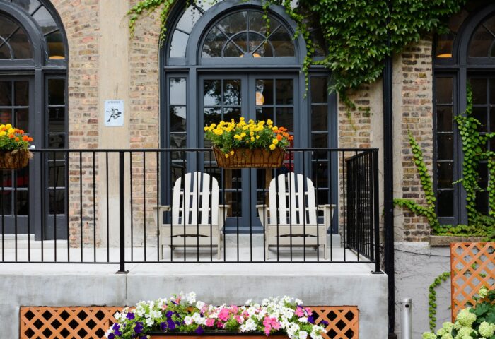 Chicago Getaway Hostel's gay-friendly hotel facade. Balcony with chairs, flowers, and brick. Ideal for gay travelers seeking a getaway.