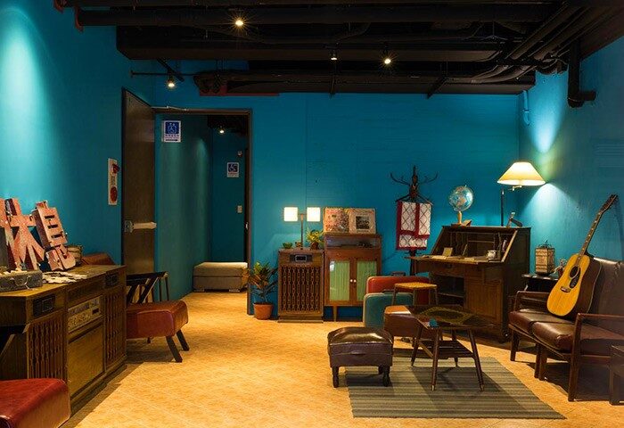 Cho Hotel's stylish lounge area. Gay-friendly hotel with vintage decor, blue walls, and cozy seating. A welcoming space for gay travelers.