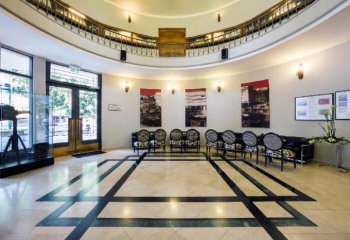 Cinema Hotel, an Atlas Boutique Hotel lobby. Gay-friendly hotel with a vintage camera, seating area, and balcony. Interior design.