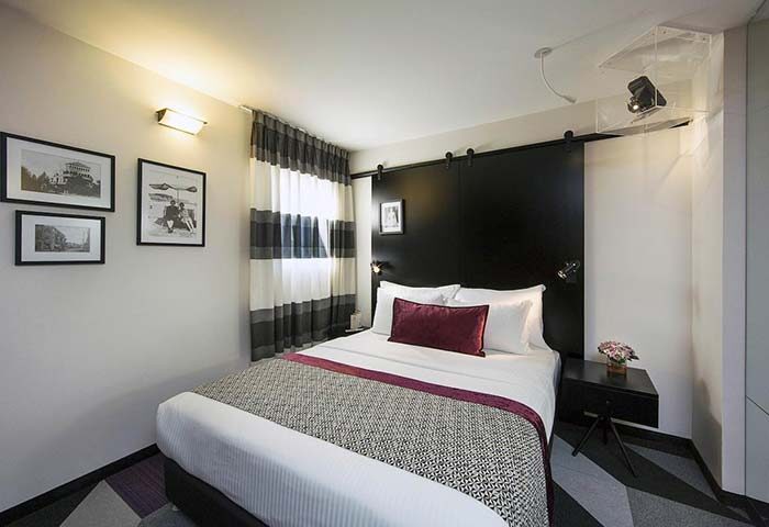 Cinema Hotel, an Atlas Boutique Hotel room. Gay-friendly hotel with black headboard, striped curtains, and modern decor. Ideal for gay travel.