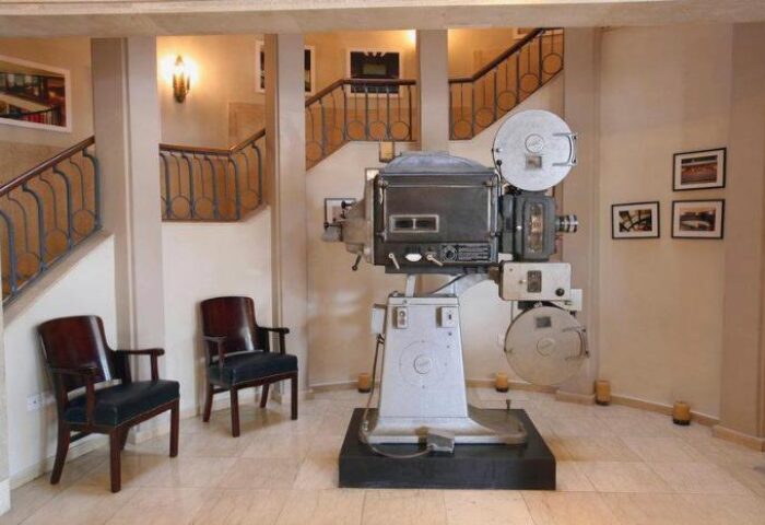 Cinema Hotel, an Atlas Boutique Hotel: Lobby with vintage film projector display. Gay-friendly hotel interior with seating and staircase.