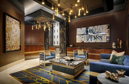 Lobby at the gay-friendly Circa Resort and Casino, an adults-only hotel. Modern design with blue seating, marble accents, and stylish lighting.