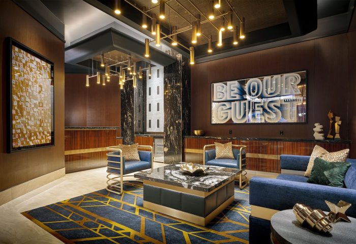 Lobby at the gay-friendly Circa Resort and Casino, an adults-only hotel. Modern design with blue seating, marble accents, and stylish lighting.