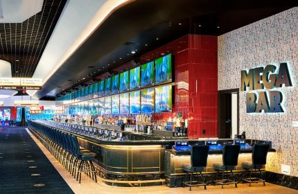 Mega Bar at Circa Resort and Casino, an adults-only, gay-friendly hotel. Long bar with many TVs, perfect for gay men travel.