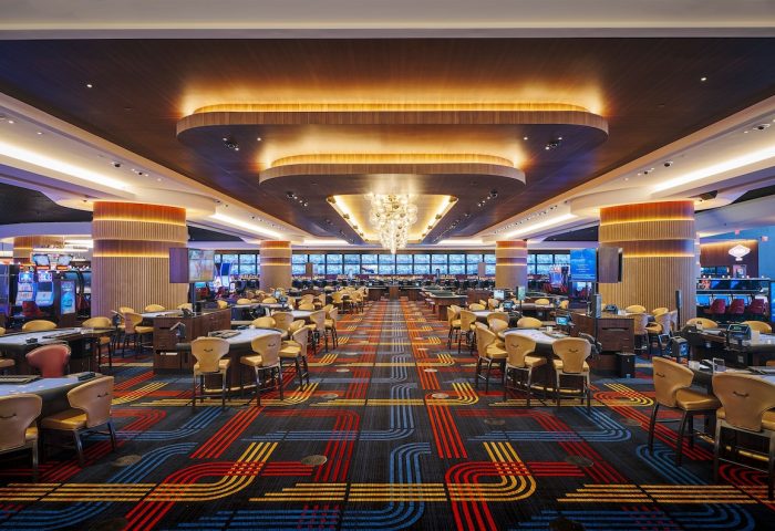 Circa Resort and Casino's gaming floor, an adults-only, gay-friendly hotel. Tables and slot machines under a decorative ceiling.