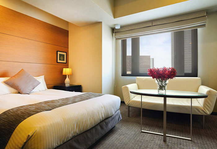 Citadines Central Shinjuku Tokyo gay-friendly hotel room. Bed, sofa, & city view. A comfortable stay in Shinjuku's heart for gay travelers.