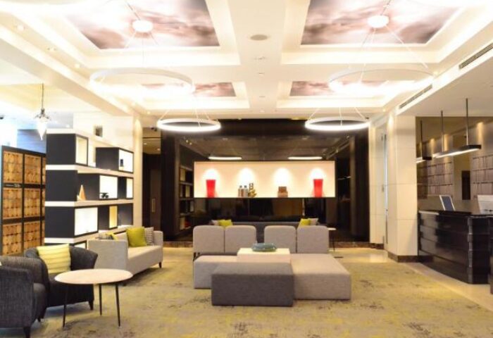 Citadines Central Shinjuku Tokyo lobby. Gay-friendly hotel with modern design, seating area, and unique lighting. Perfect for gay travel.