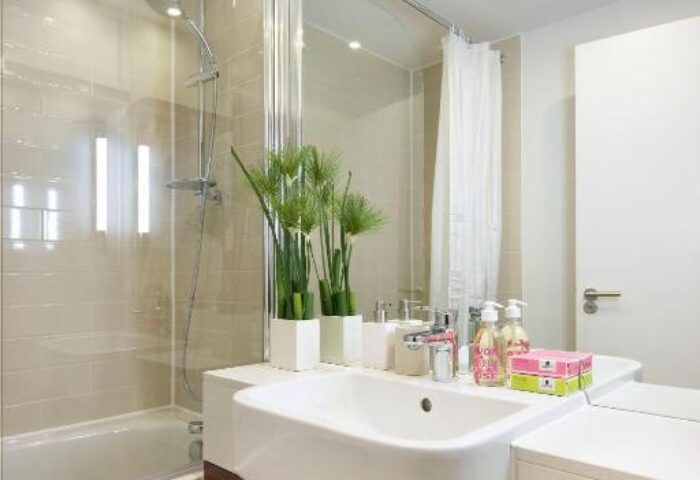 Bathroom at Citadines Holborn-Convent Garden London, a gay-friendly hotel. Features a tub-shower combo, modern sink, and sleek design.