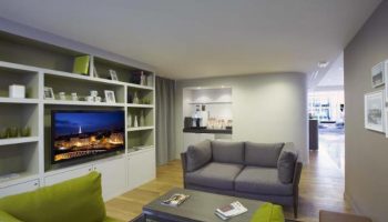 Citadines Les Halles Paris gay-friendly hotel living area. Pet-friendly serviced apartment with TV, sofa, and kitchenette for gay travel.