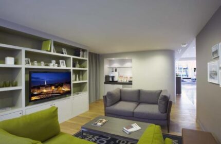 Citadines Les Halles Paris gay-friendly hotel living area. Pet-friendly serviced apartment with TV, sofa, and kitchenette for gay travel.