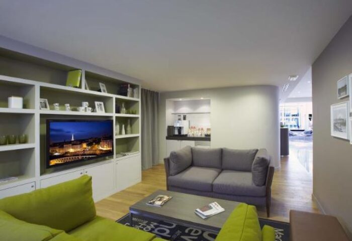 Citadines Les Halles Paris gay-friendly hotel living area. Pet-friendly serviced apartment with TV, sofa, and kitchenette for gay travel.