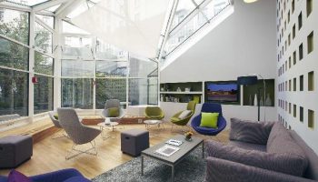 Citadines Les Halles Paris's bright lounge. Gay-friendly, pet-friendly hotel with modern decor, skylight, and comfortable seating. Ideal Paris stay.