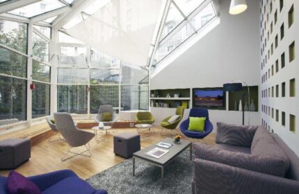 Citadines Les Halles Paris's bright lounge. Gay-friendly, pet-friendly hotel with modern decor, skylight, and comfortable seating. Ideal Paris stay.