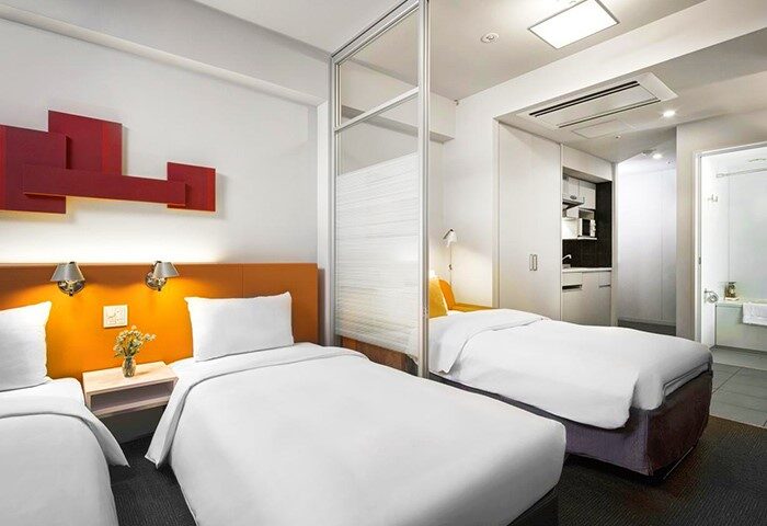 Citadines Shinjuku Hotel room. Gay-friendly hotel with twin beds, kitchenette, and bathroom. Modern design for gay travelers in Shinjuku, Tokyo.