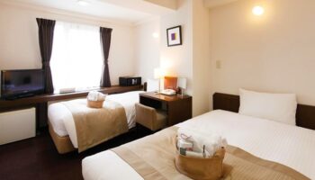 City Hotel Lonestar gay-friendly room with two beds, desk, TV, safe. Comfortable stay for gay travelers.