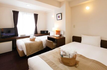 City Hotel Lonestar gay-friendly room with two beds, desk, TV, safe. Comfortable stay for gay travelers.