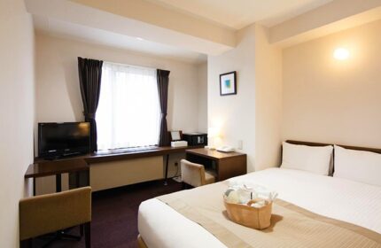 City Hotel Lonestar room. Gay-friendly hotel with a bed, desk, TV, and window. A basket of amenities sits on the bed. Modern, clean design.