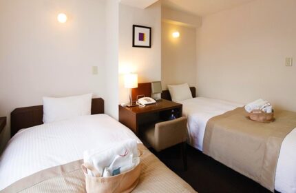 City Hotel Lonestar gay-friendly room with twin beds, desk, lamp, and towels. A comfortable stay for gay travelers.