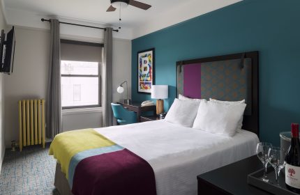 City Suites Chicago gay-friendly hotel room. Queen bed, desk, wine, and glasses. A great place to stay for gay men visiting Chicago.