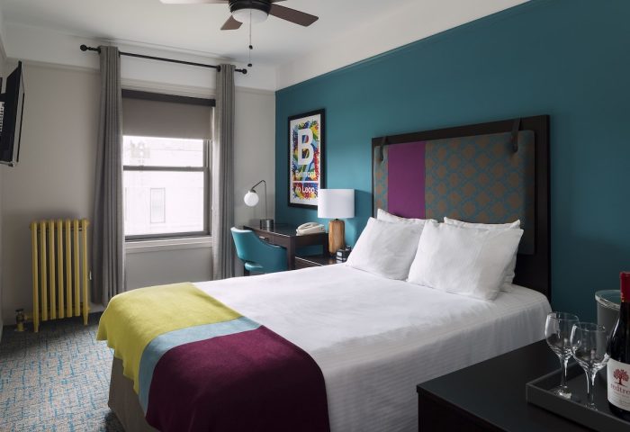 City Suites Chicago gay-friendly hotel room. Queen bed, desk, wine, and glasses. A great place to stay for gay men visiting Chicago.