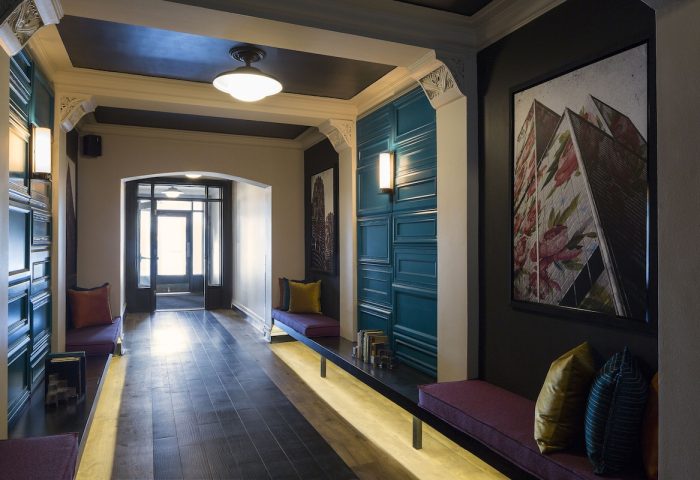 City Suites Chicago gay-friendly hotel interior. Hallway with benches, artwork, and decorative wall panels. Modern design elements.