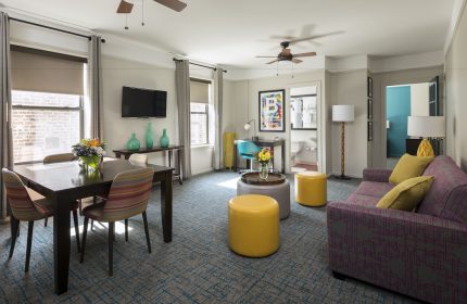 City Suites Chicago gay-friendly hotel room. Living area with dining table, sofa, and desk. Modern design for LGBTQ+ travelers.