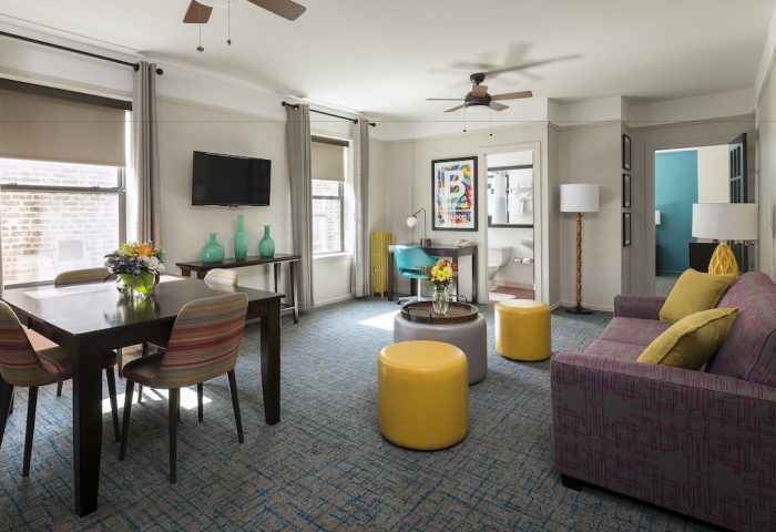 City Suites Chicago gay-friendly hotel room. Living area with dining table, sofa, and desk. Modern design for LGBTQ+ travelers.