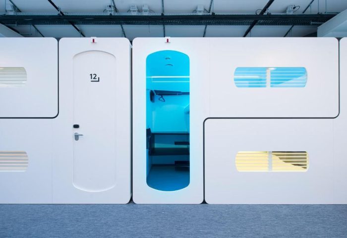 CityHub Amsterdam interior. Modern, pod-style hotel room. White modular units with blue lighting. Gay-friendly hotel design, Amsterdam travel.