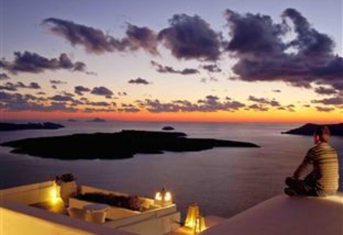 Gay-Friendly Cliff Side Suites hotel view at sunset. Man looks over the ocean. Luxury travel destination. Romantic getaway.
