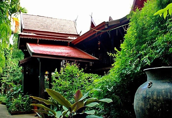 Club One Seven Gay Men Hotel Chiang Mai exterior. Lush greenery surrounds traditional Thai architecture. Gay-friendly hotel in Thailand.