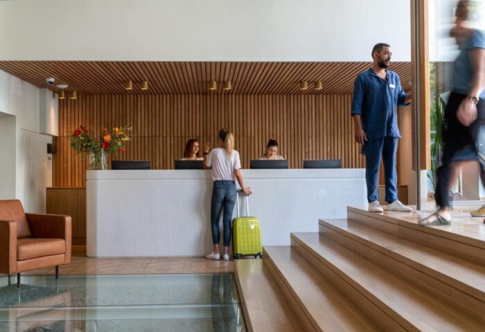 Coco-mat Athens BC gay-friendly hotel lobby. Guests check in at the front desk. Modern design with wood accents and a welcoming atmosphere.