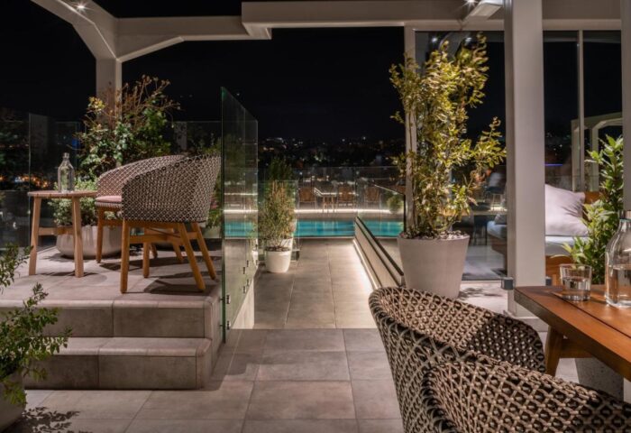 Coco-mat Athens BC gay-friendly hotel rooftop terrace at night. Outdoor seating area with pool view. A great spot for gay travelers.