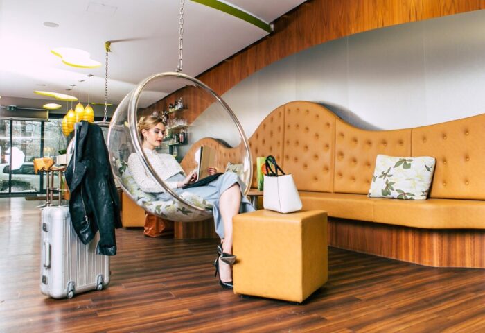 Cocoon Sendlinger Tor: Woman relaxing in bubble chair at gay-friendly hotel. Modern design, stylish travel. Munich hotel interior.