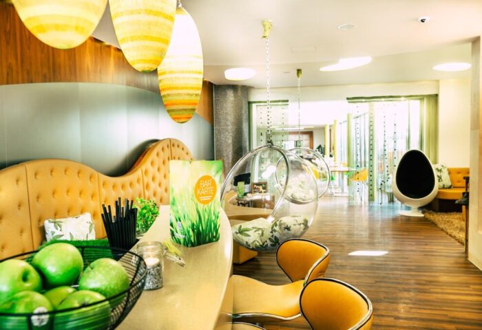 Cocoon Sendlinger Tor's gay-friendly hotel bar. Stylish interior with hanging bubble chairs, modern design, and a welcoming atmosphere. Munich gay travel.