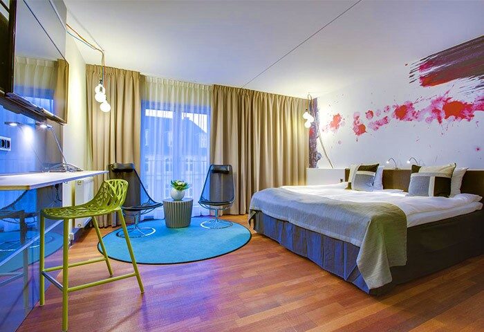 Comfort Hotel Vesterbro's gay-friendly room. Modern design with a bed, chairs, desk, and vibrant wall art. A stylish choice for gay travelers.