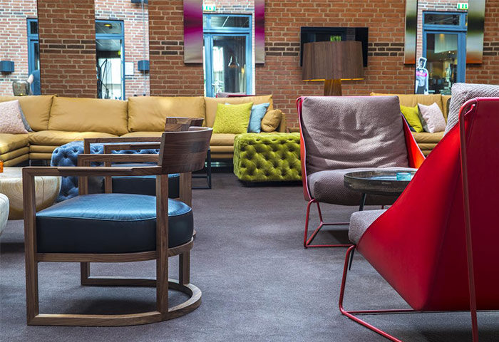 Comfort Hotel Vesterbro's stylish lounge area. Gay-friendly hotel with modern furniture, brick walls, and colorful accents. Relaxing space.