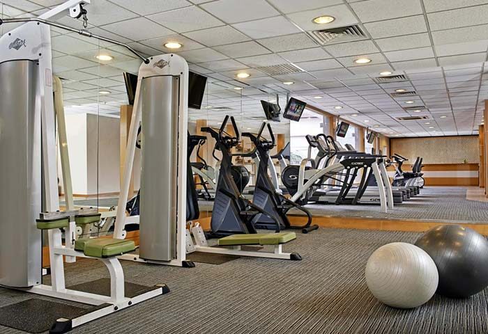 Gym at gay-friendly Concorde Hotel Kuala Lumpur. Fitness equipment includes treadmills, elliptical machines, and weight machines. Exercise balls in foreground.