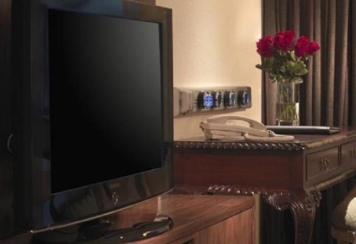 Concorde Hotel Kuala Lumpur gay-friendly room detail. TV, desk with roses, and phone. A comfortable stay for gay travelers in Kuala Lumpur.