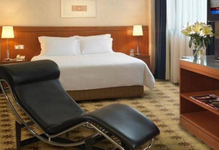 Concorde Hotel Kuala Lumpur room. Gay-friendly hotel with a black chaise lounge, bed, flowers, and tv. Modern design for gay travelers.